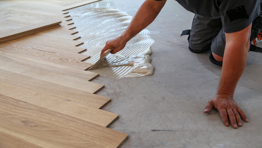 person installing parquet flooring