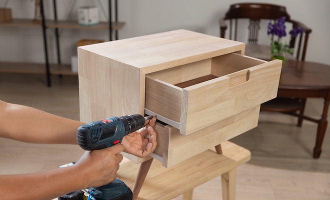 arms with screwdriver adjusting a cabinet