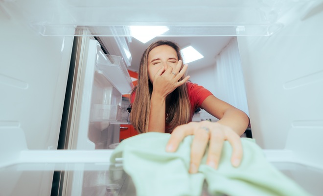 Woman cleaning smelly fridge