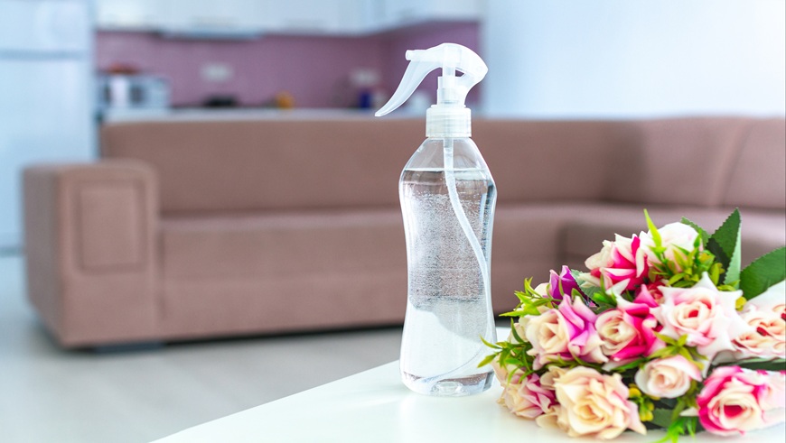 Air freshener and flowers on table