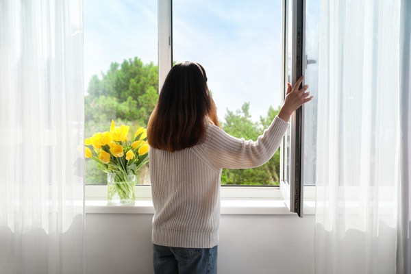 Woman in front of open window