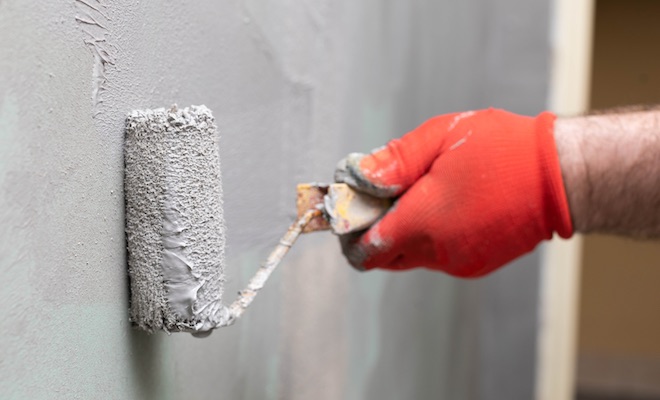 tradesman applying damp insulation paint