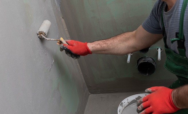 tradesman applying damp proofing treatment