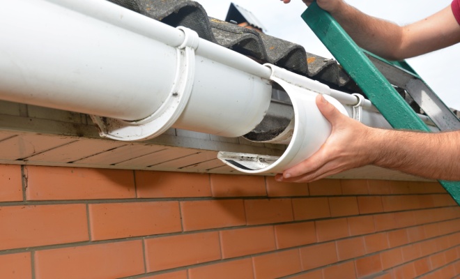 Tradesperson repairing a gutter