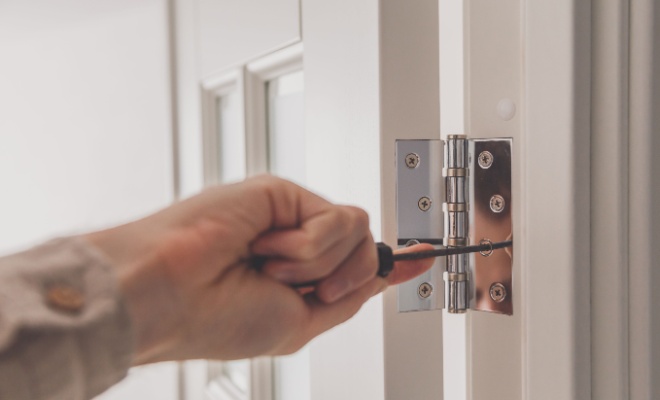 screwdriver on a door hinge