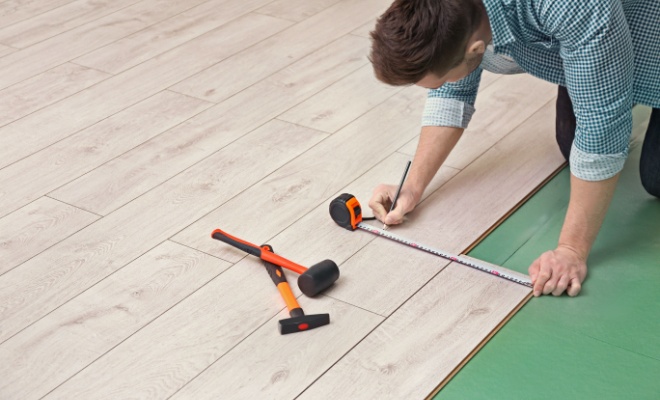 man measuring during laminate floor installation