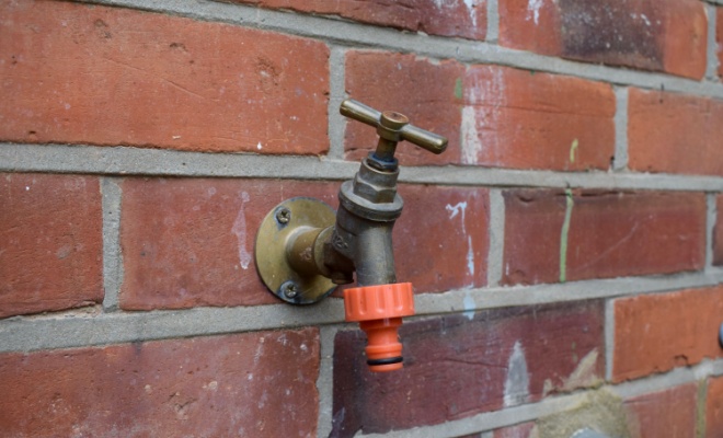 close up of a tap on a brick wall