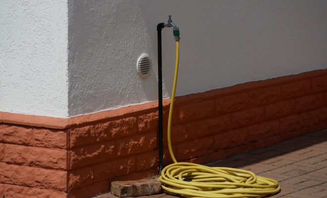 yellow pipe attached to outdoor tap