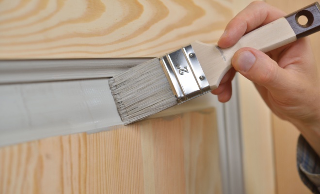 small paintbrush applying grey paint