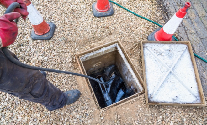 person inspecting drain