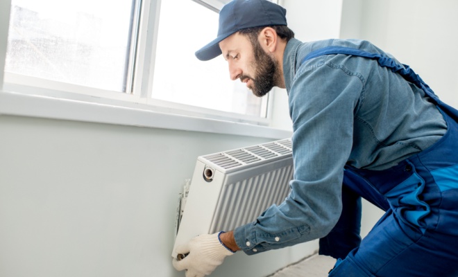 Tradesperson removing radiator off the wall