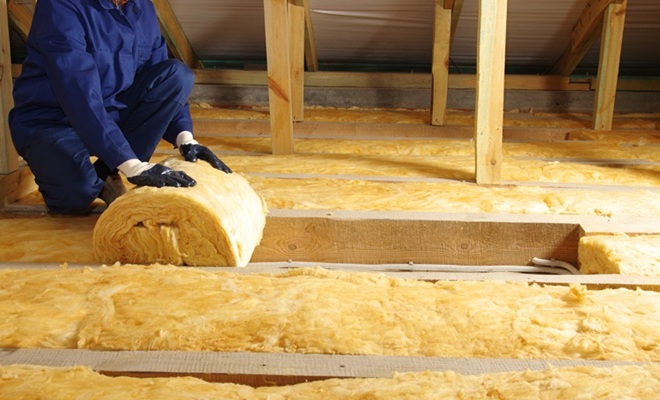 Man installing roll insulation
