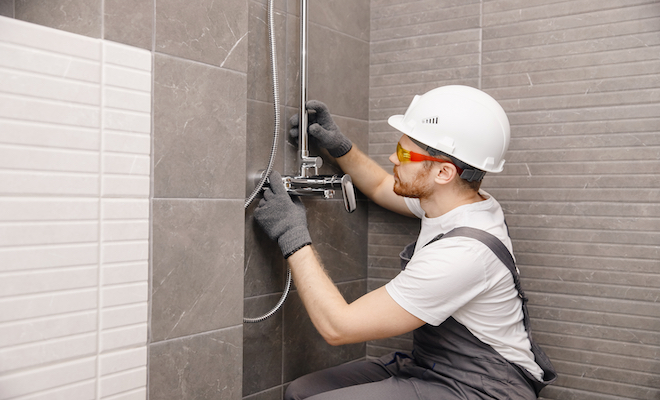 person in hardhat installing shower