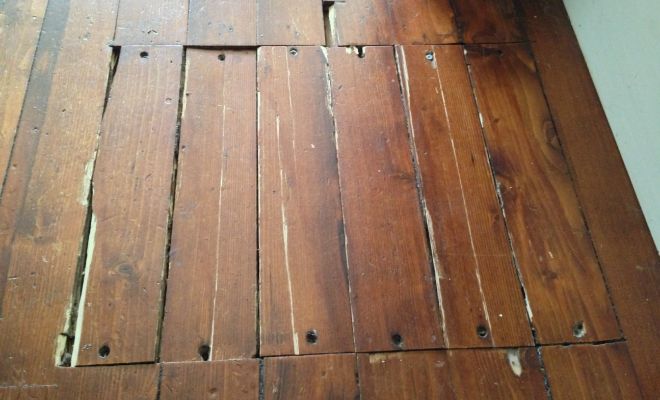 worn floorboards featuring square of repairs