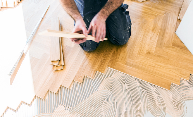 person fitting wooden parquet flooring