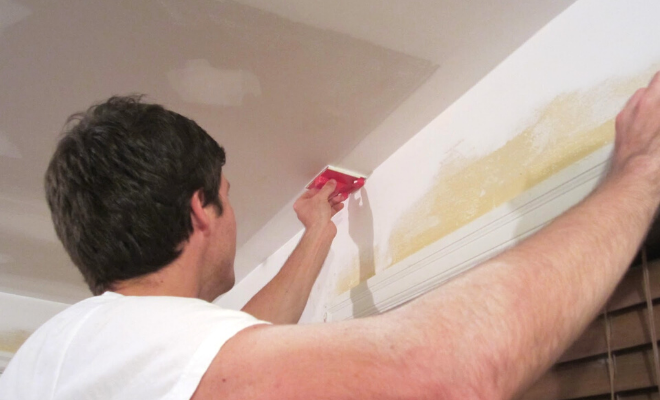 Man removing artex from ceiling