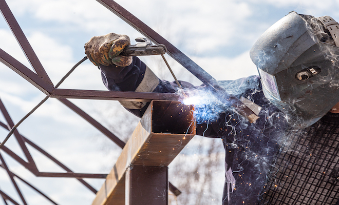 man welding metal frame