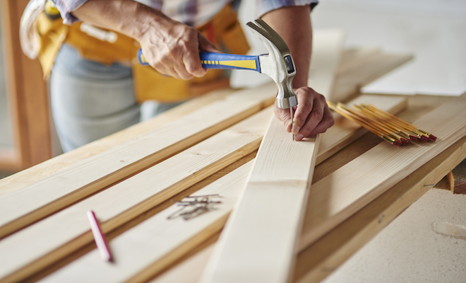 person hammering nails into wood