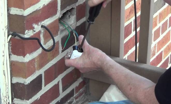 Man fitting outdoor socket