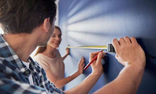 people measuring a wall