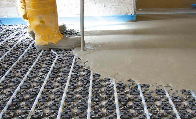 Screed being poured on top of underfloor heating