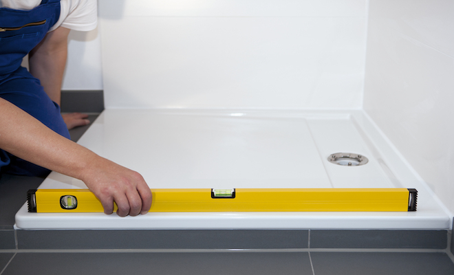 person measuring shower tray