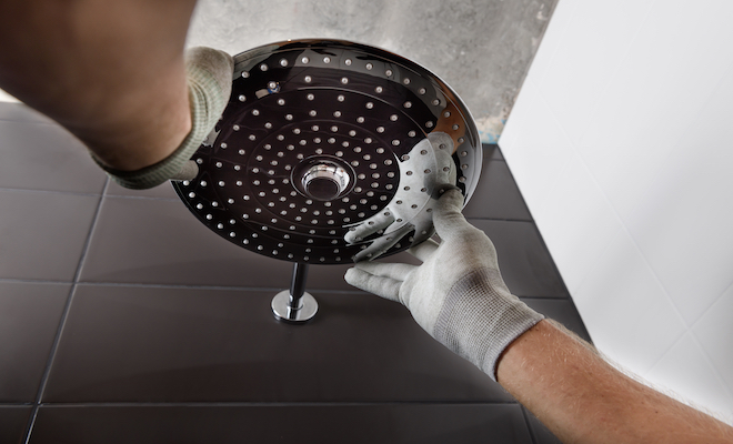 person installing shower head