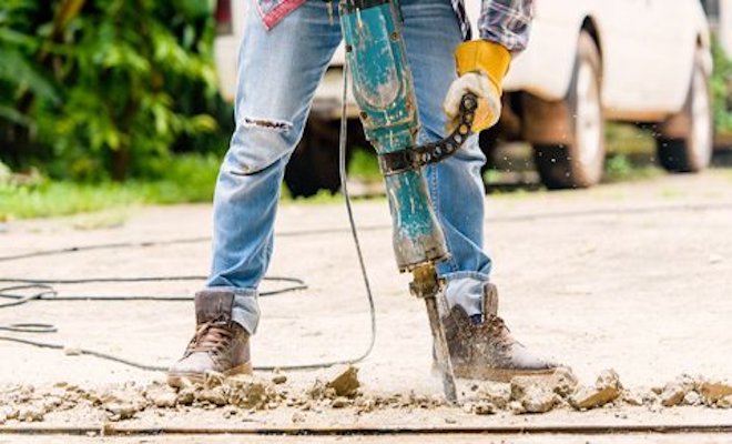 Tradesperson removing floor screed