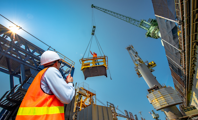 someone inspecting a crane and building site