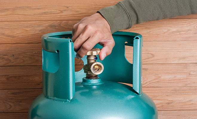 lpg cylinder with hand unscrewing it